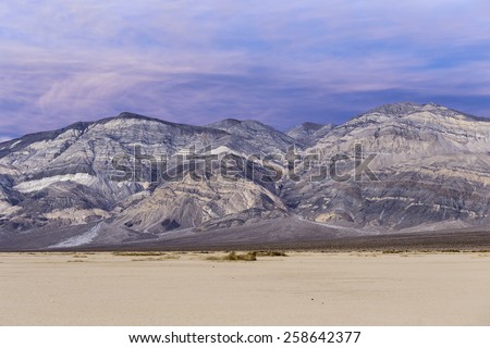 Sunset landscape in Death Valley national park. Colorful stripped mountains in desert with purple sky. Death Valley national park, California