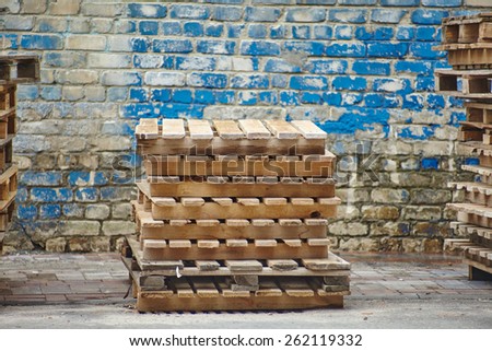 A stack of wooden pallets on the background of wooden wall
