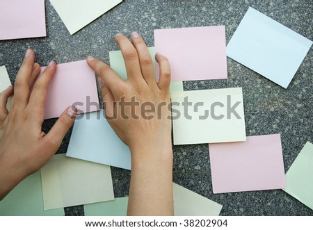 Hand attaching multi-coloured stickers on a wall