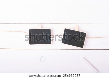 Two isolated chalk boards on a white wooden background with chalk.
