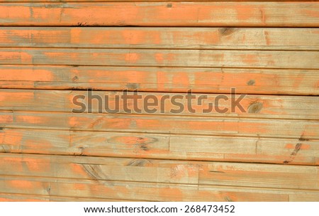 Old wooden wall with worn out paint. Grungy aged exterior wall of old building. Painted house wall. Weathered warehouse wall. Orange painted wall, dirty and old texture.
