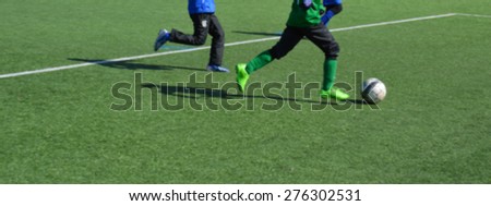 Young female soccer players running in cold weather - blurred image - use for example as banner. European football player girls on turf field. Spring or autumn weather outdoors.