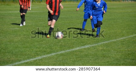 Young female soccer players running on grass field. European football girl team. Young women playing soccer. Female players in tournament. Blurred image.