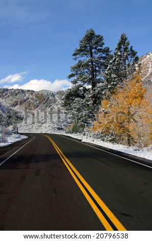 Empty mountain road after early snow in the Fall