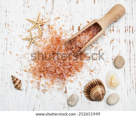 sea salt in wooden spoon with sea shells and starfish on wooden background