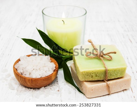 spa setting with candle, handmade soap and salt on a old wooden background