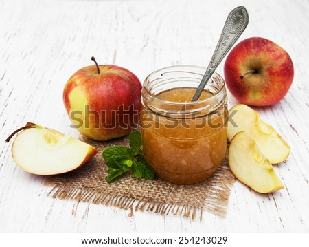 Apple jam and fresh apple on a wooden background