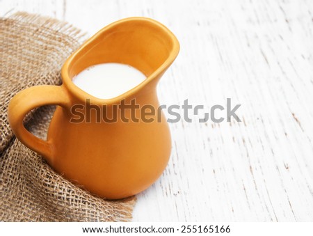 milk in pitcher on a old wooden background