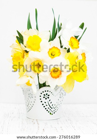 Daffodils in a vase  with empty tag on a old wooden background