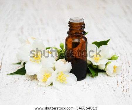 Massage oil with jasmine flowers on a wooden background