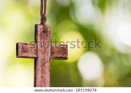 wooden cross hanging against bur nature background