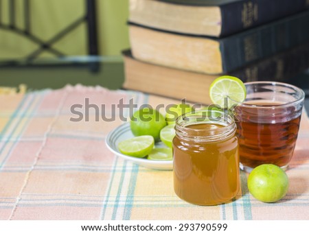 Freshly cut half and whole lemon with a cup of tea with the books of Holy Bibles on retro the table