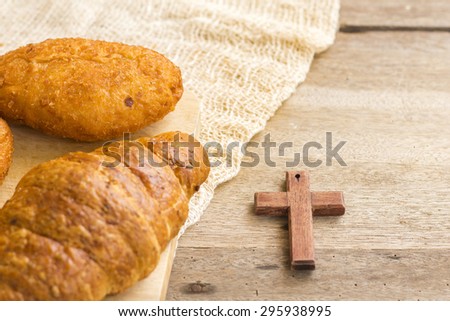 bread and  wooden cross on the wooden background show christian symbol that Jesus is the bread of life from bible verses John 6:35