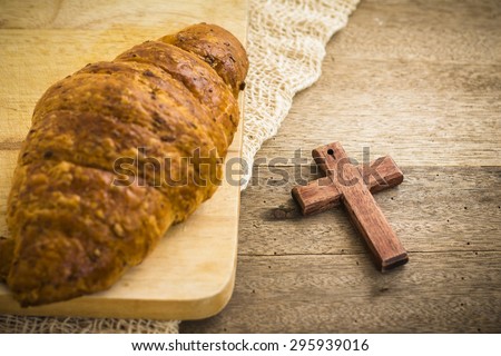 bread and  wooden cross on the wooden background show christian symbol that Jesus is the bread of life from bible verses John 6:35