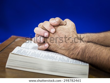 CHIANGMAI, THAILAND - July 22, 2015. Praying hands of a man on the open  bible (New International  Version) christian believe that  the bible is the word of God and try to reading the bible everyday.