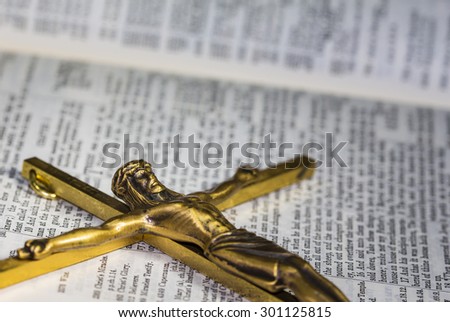 CHIANGMAI, THAILAND - July 30, 2015. Brass Cross with crucified Jesus over  the  bible (New International version ) christian believe that the bible is the word of God and try to read bible everyday.