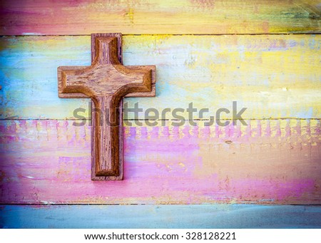 wooden cross on colorful painted  wooden texture background