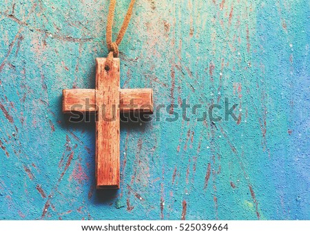 Image of wooden cross on blue retro background with copy space, christian background or concept