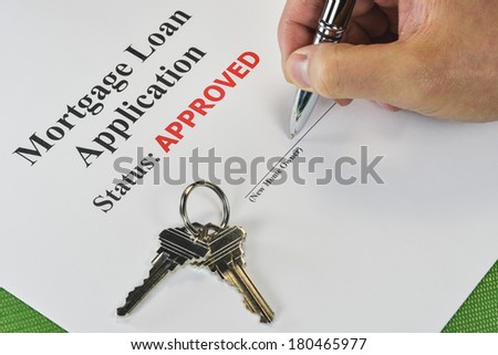 Hand Signing An Approved Real Estate Mortgage Loan Document With House Keys
