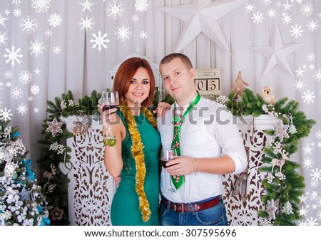 Beautiful European young couple celebrating new year. Boy and girl are holding champagne glasses.