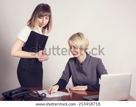 Business woman at work. Woman in the office. Two business woman working in the office. Work . checking and signing of accounting and tax records.
