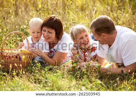 Father, mother, daughter and son walking in the countryside. Parents and children dressed in traditional Ukrainian clothes. Young family on a picnic.