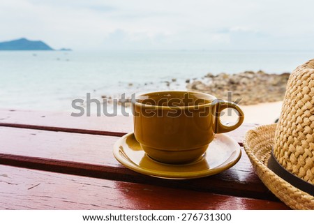 coffee cup on wooden table with ocean background