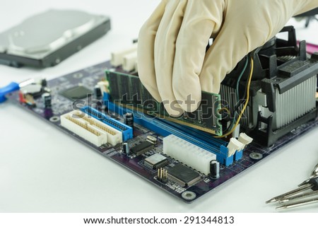 hand holding random access memory to install in socket, installing RAM on PC main board