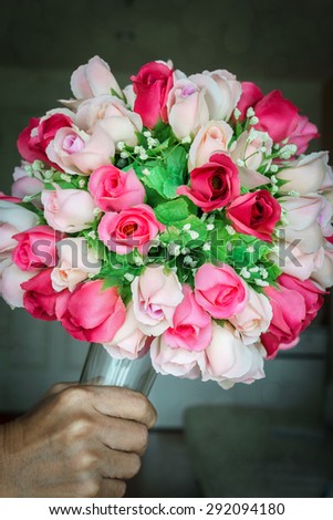 Colorful bouquet of rose made from fabric, Man hand holding bouquet