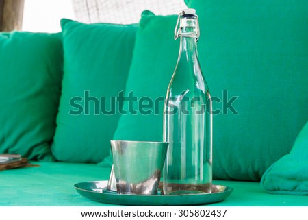 Glass Water bottle prepare for guest with colorful pillow in background