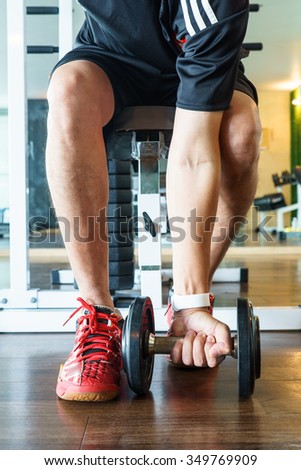 Man exercises with dumbbells in fitness gym, Man and Exercise Equipment