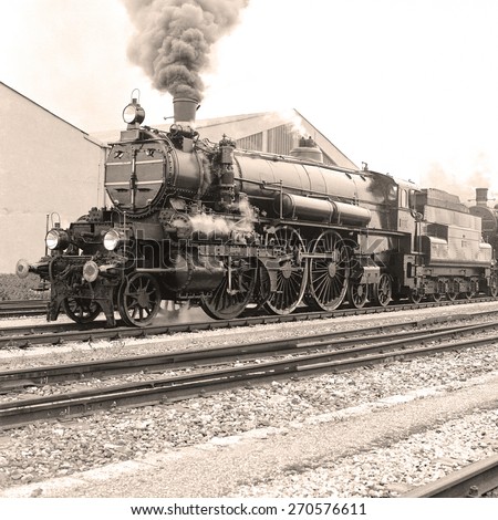 Side view of an old-fashioned steam locomotive in an austrian railway station. Scan from a B&W negative.