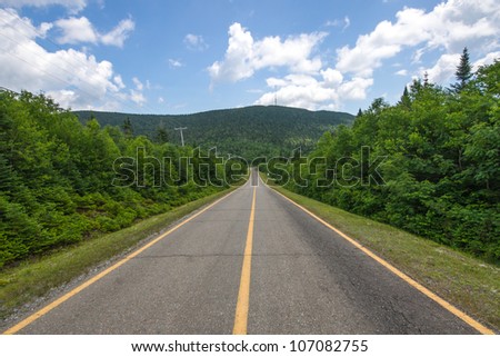 Country Road without vehicles, and in background, the Mount St. Joseph in Quebec.