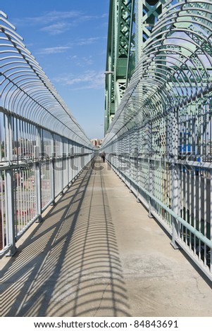 Path from the top of a metal structure of a bridge in Montreal, on the west side, and one person went to Montreal for this trail in the background.