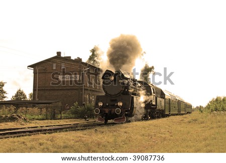 Old retro steam train starting from the small station