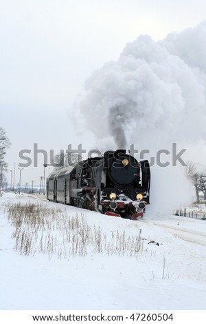 Old retro steam train starting from the station during wintertime