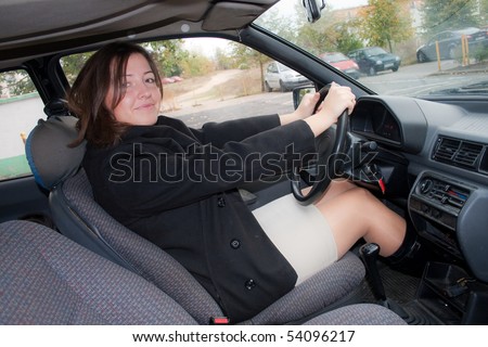 Adult woman in mini skirt sitting on the driver\'s seat
