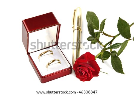 stock photo Wedding rings in red box small red rose and golden pen 