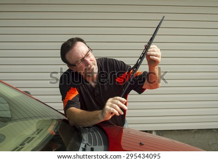 Mechanic installing a new windshield wiper blade on a vehicle.