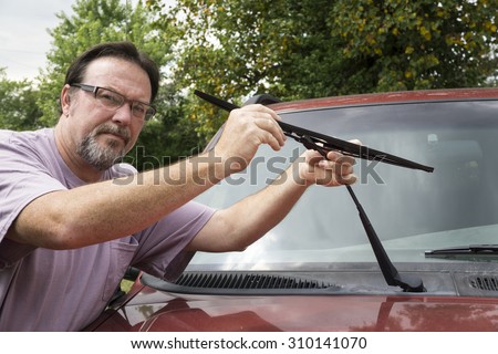Mechanic taking worn wiper blade off of a customers older truck.