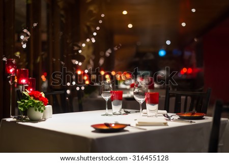 romantic dinner setup, red decoration with candle light in a restaurant. Selective focus.