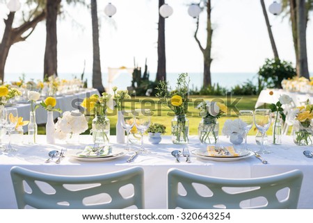 champagne on elegance table set up white, green and yellow flowers theme, selective focus. (set)