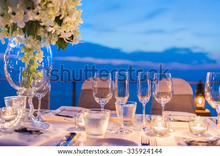 Romantic dinner setup, decoration with candle light, twilight. Selective focus.