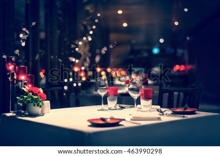 romantic dinner setup, red decoration with candle light in a restaurant. Selective focus. Vintage color.