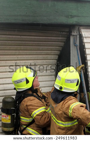 Melbourne, Victoria, Australia - 2011 July 10: Fire fighters using a crow bar to gain access to a garage on fire in an residential area.