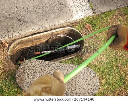 Hobart, Australia - 2015, April 11: Installation of  a green 72 fiber optic ribbon cable in a cable duct through a roadside communications pit, used for the National Broadband Network in Australia.