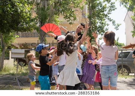 Date: 17/5/2015. Location: Park in Athens Greece. Magic show with Tristan. Happy kids trying to catch confetti.