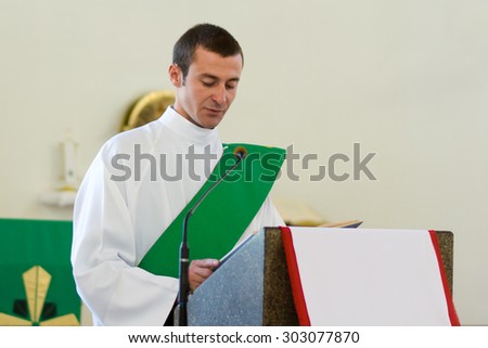KRIVOY ROG, UKRAINE: 24 OF AUGUST 2014. Young Catholic Church priest reading indoors