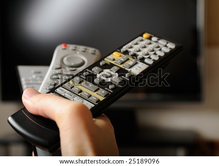 Hand with TV remote controls