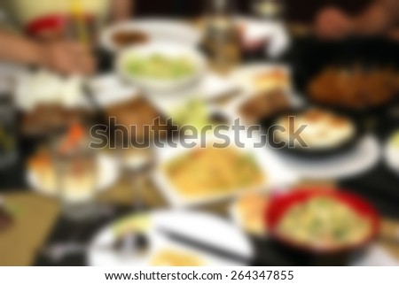 Blurred Background of Dinner in chinese restaurant with plenty of food, dining table